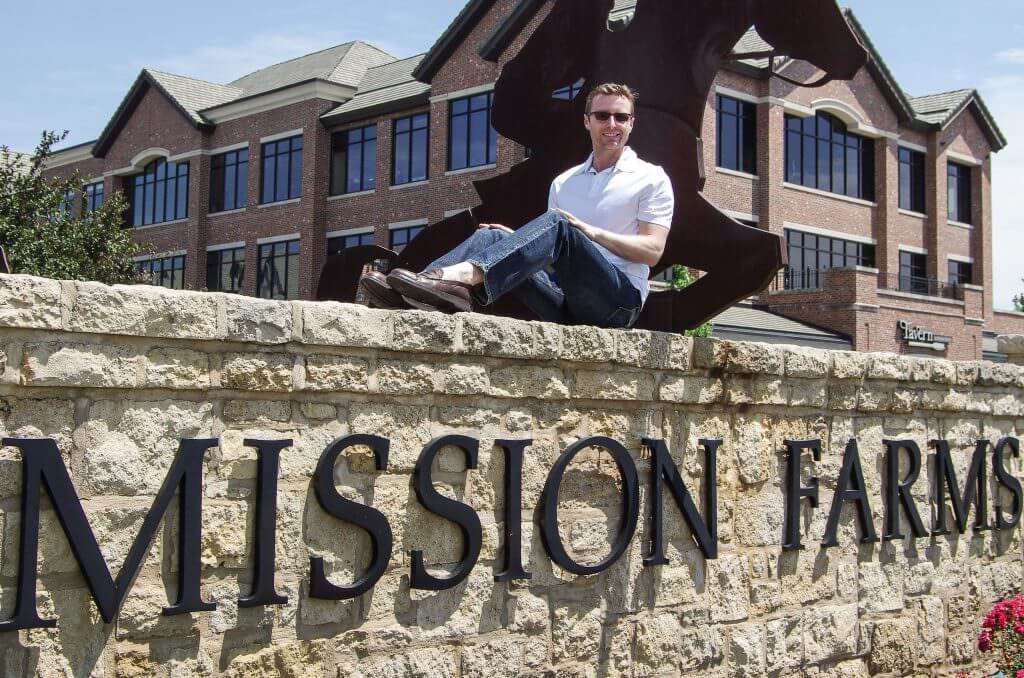 This is a picture of Matthew T. Kincaid, a real estate lawyer, is Leawood, Kansas.  He is sitting on top of a wall in Mission Farms.